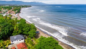 Une ville côtière dotée d’une plage, de maisons et d’une végétation luxuriante.