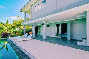 A modern house with a pool, outdoor seating, and a covered patio area. - Villa Coco (Banjar)