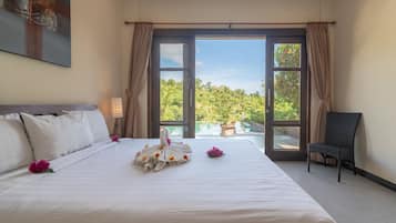 Habitación de hotel con una cama grande, una silla y vistas a una piscina y follaje por las ventanas.