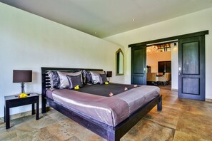 Un dormitorio amplio con una cama grande, dos mesitas de noche, un espejo y un candelabro.
