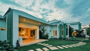 A modern house with a spacious patio, a large window, and a well-maintained garden. - Villa Zoubi Bali (Seririt)