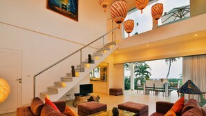 A modern interior with a staircase, a dining area, and a view of the outdoors. - Villa Zoubi Bali (Seririt)