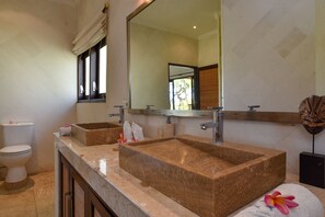 A bathroom with two large granite sinks, a toilet, and a mirror. - Villa Lumba-lumba 1 (Seririt)