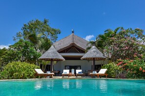 A resort with a pool, lounge chairs, and thatched-roof structures. - Villa Lumba-lumba 1 (Seririt)
