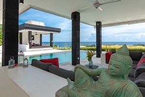 Ein modernes Interieur mit Pool, Sitzgelegenheiten im Freien und einer Buddha-Statue.