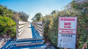 A wooden boardwalk leading to Beachwood Villas Beach Access #14, with a sign indicating to call 911 for emergencies and listing beach ordinances. - 🐟Lake Views, Bikes-Churchill By The Sea 2308 (Santa Rosa Beach)