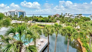 A resort with a pool surrounded by palm trees, a view of the ocean, and modern buildings in the background. - ☀️Top Floor-Gulf Views-Pools-30A-Gulf Place Getaway (Santa Rosa Beach)