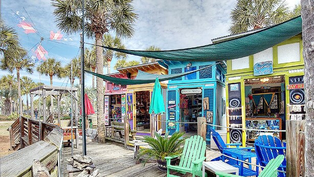A wooden deck with green Adirondack chairs, a small table, and a tiki bar with colorful signage. - ☀️Top Floor-Gulf Views-Pools-30A-Gulf Place Getaway (Santa Rosa Beach)