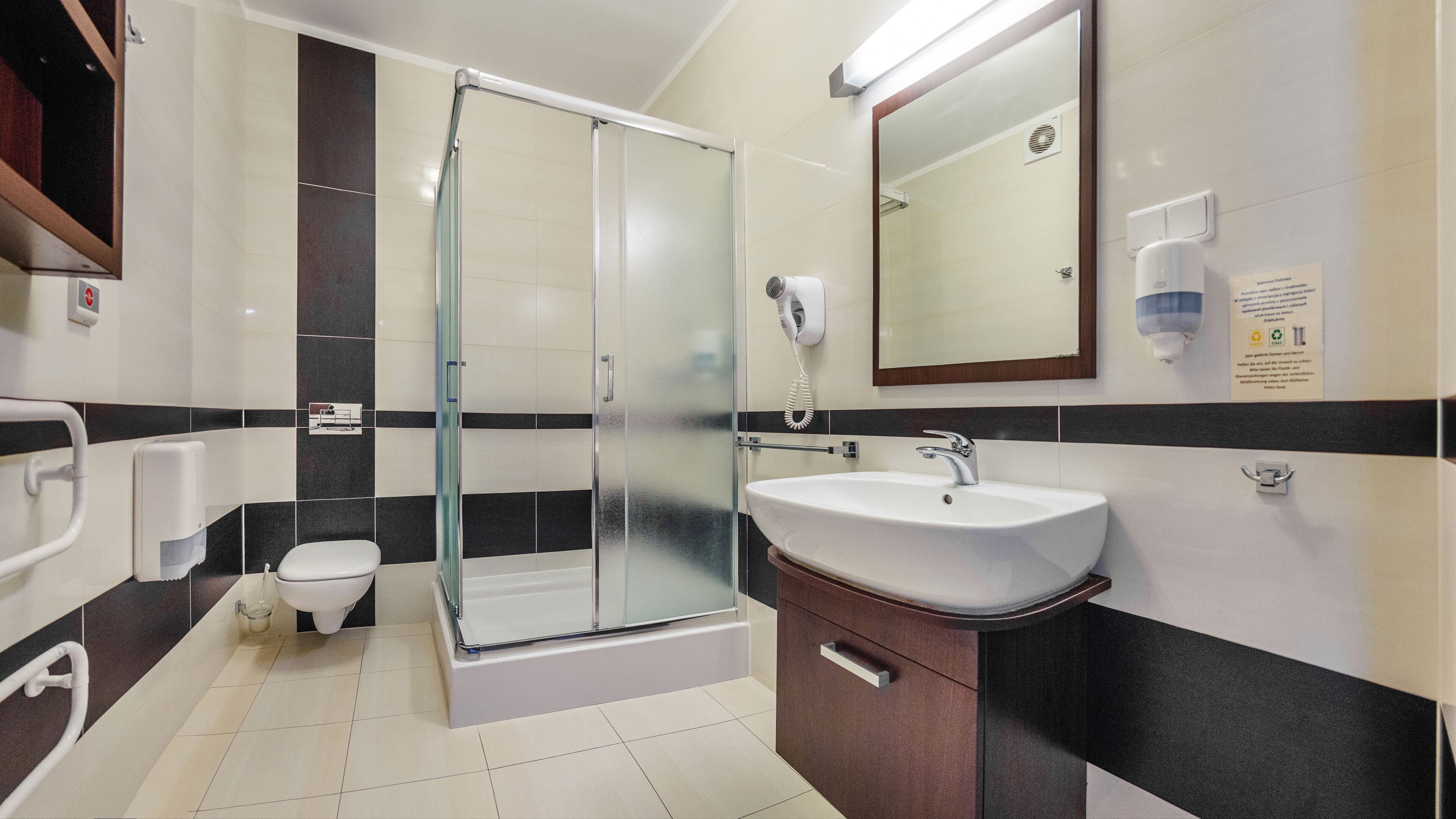 A modern bathroom with a glass-enclosed shower, a white sink, and a mirror above the sink.