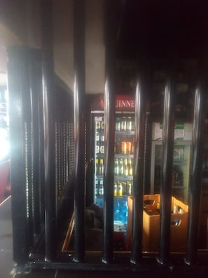 A vending machine area with a 'JINNE' sign, surrounded by metal bars. - Silk Guest House (Nairobi)