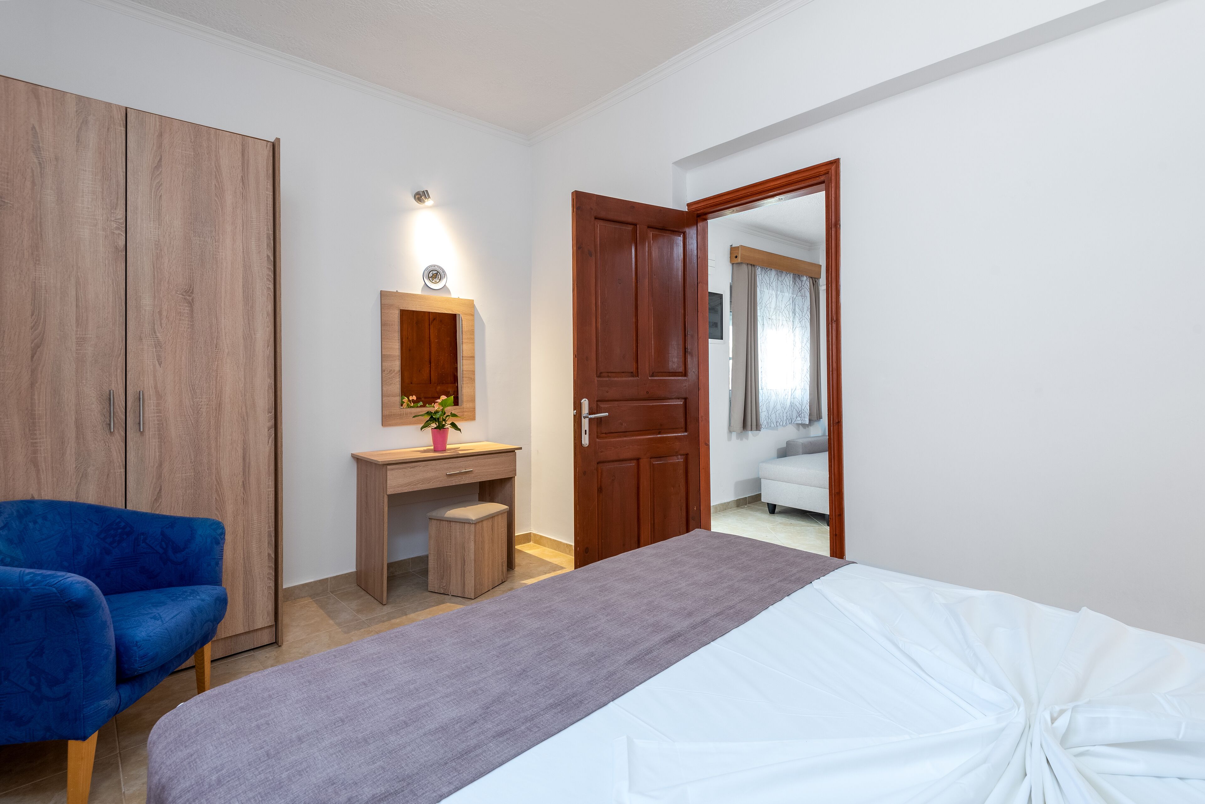 Ein Schlafzimmer mit Bett, Schreibtisch, Kleiderschrank und Stuhl.