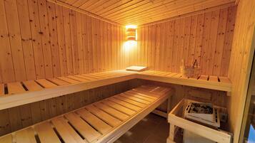 Una sauna con bancos de madera y una lámpara en el centro.