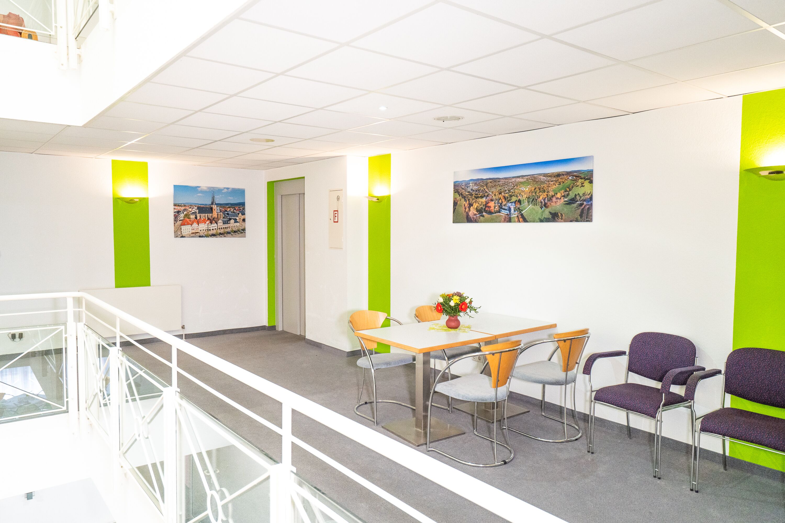 Un espacio de oficina moderno con una mesa de reuniones, sillas y una escalera.