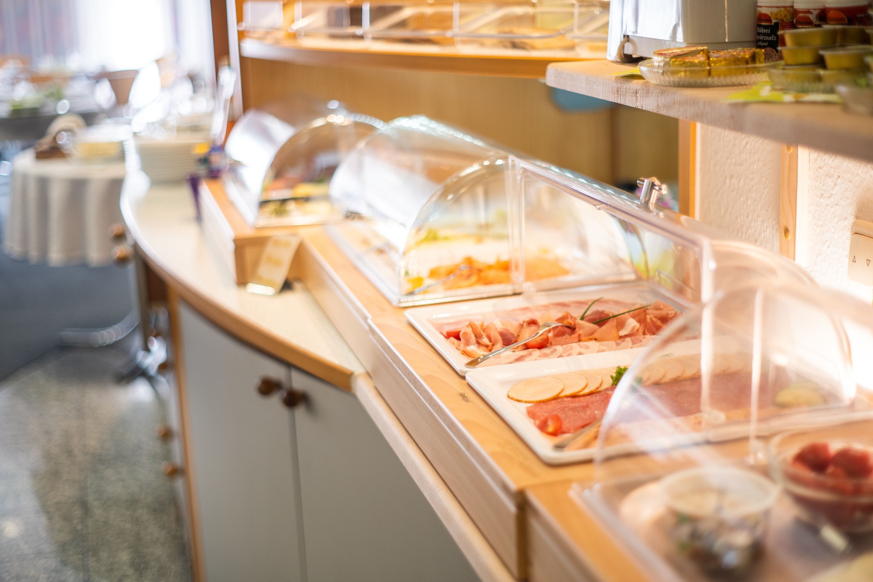 A buffet with various food items under glass covers.