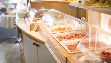 A buffet with various food items under glass covers.