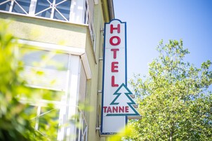 Un letrero de hotel con un icono de montaña y la palabra 'HOTEL' en letras rojas.