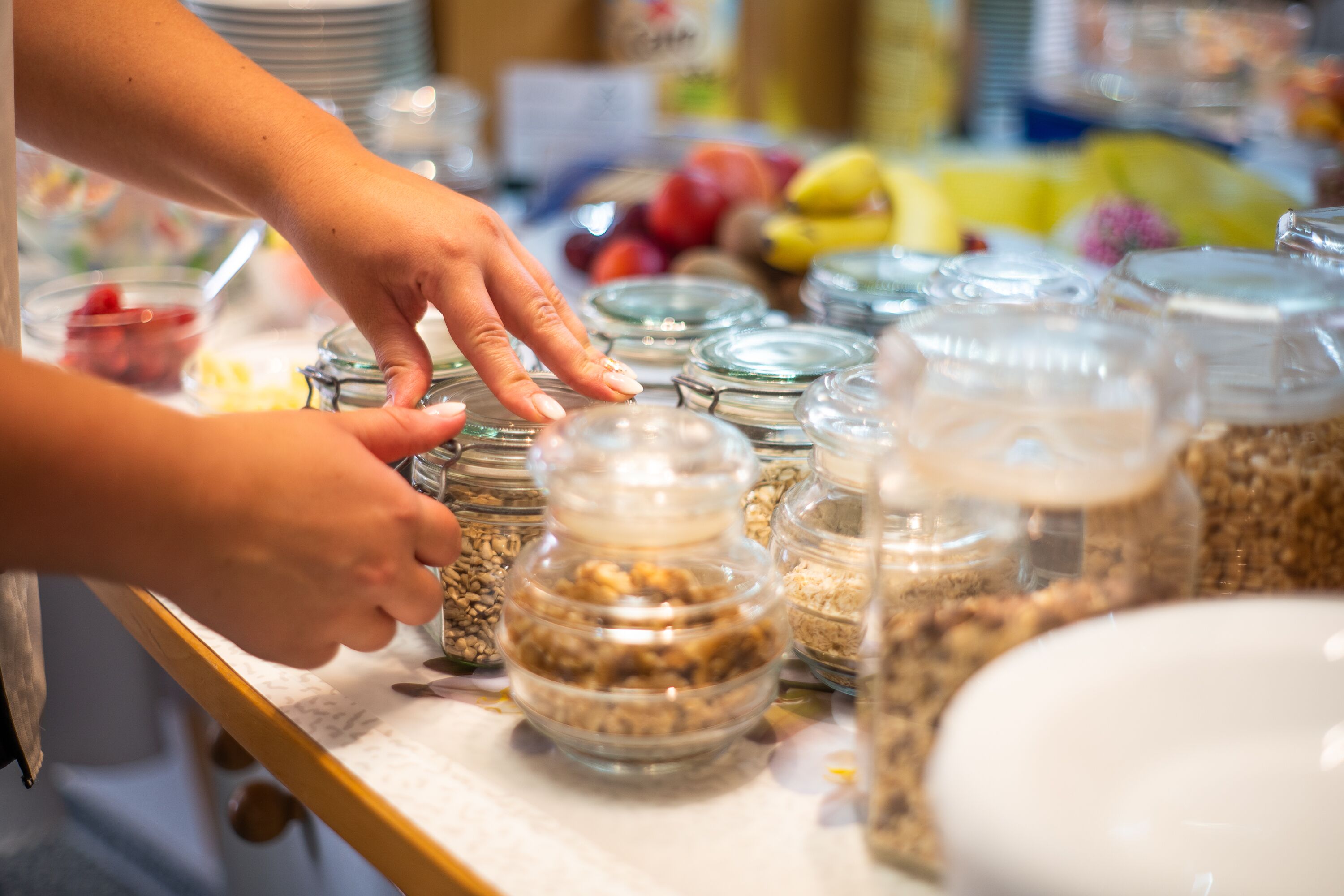A buffet table with various food items in glass containers.