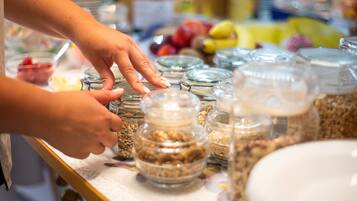 A buffet table with various food items in glass containers.