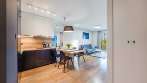 Cozinha moderna com área de refeições, sofá e vista para o exterior.