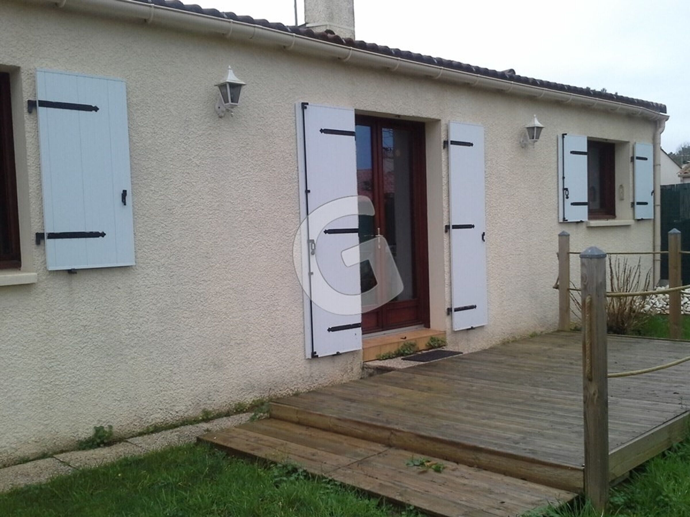 A house with a wooden deck, white exterior walls, and shutters on the windows.