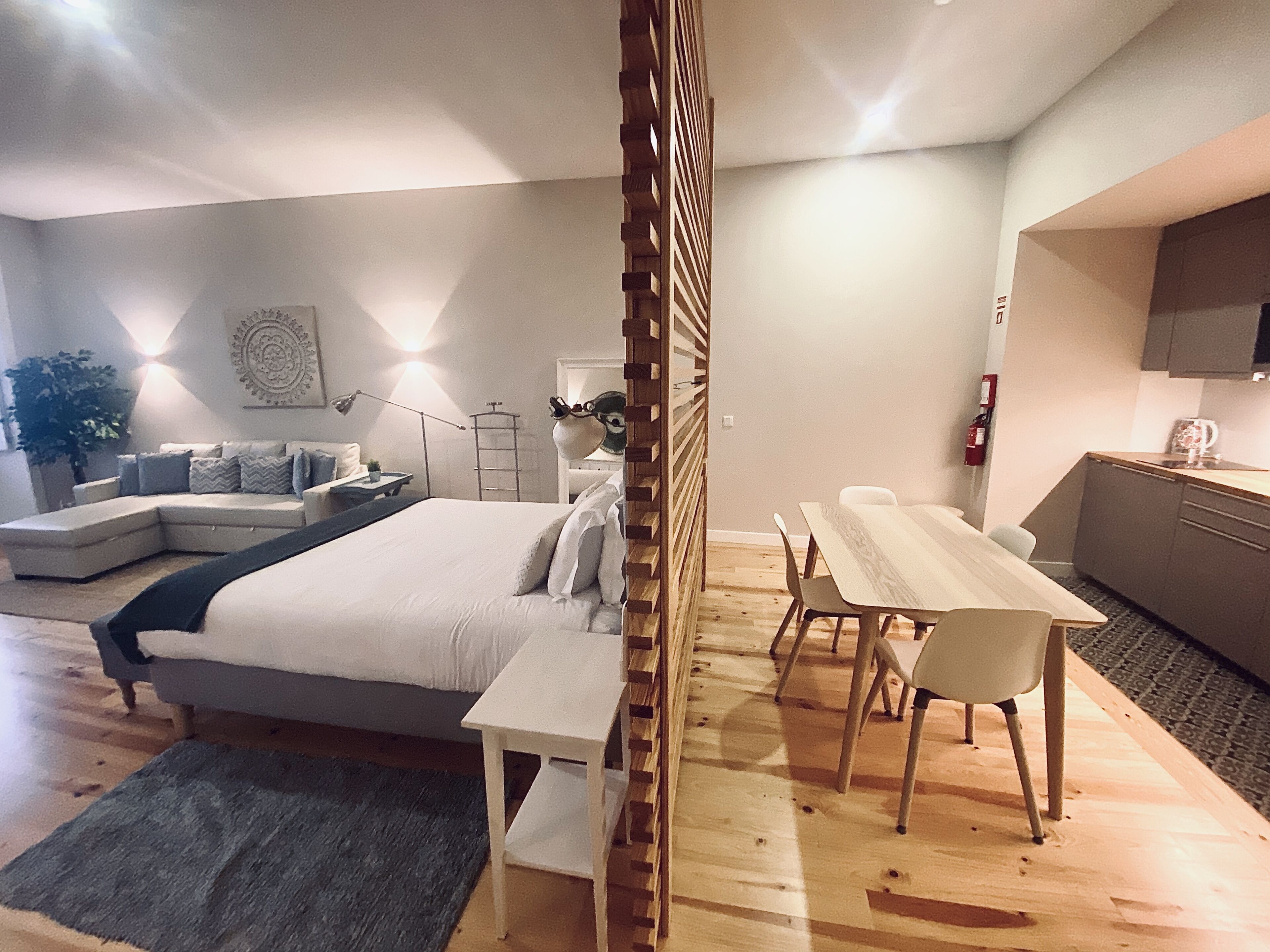 Un dormitorio moderno con una cama grande, un escritorio pequeño y una zona de estar.