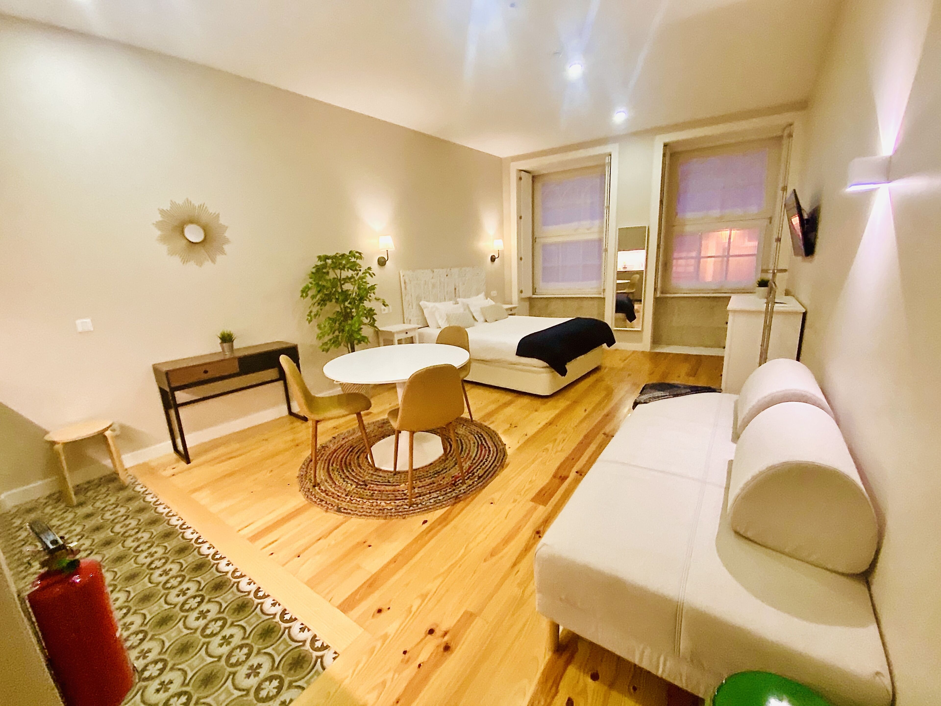 A modern living room with a round table, a sofa, and a bed.