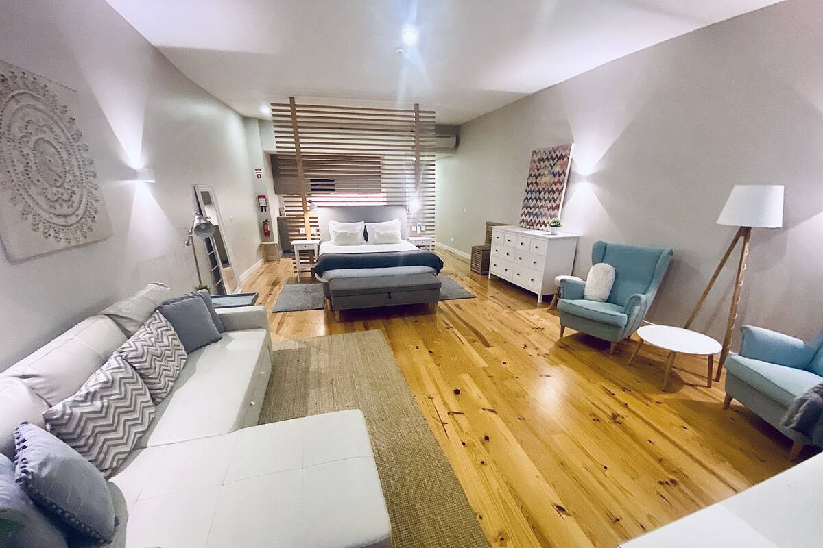 A modern living room with a sofa, armchair, and a small table.