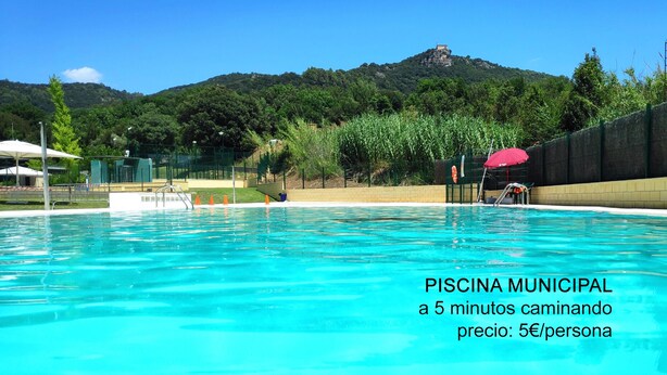 A municipal swimming pool with clear blue water, surrounded by a fence and greenery. - Ca la iaia - Village house in the old town of Amer (Amer)