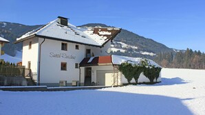Ein weißes Gebäude mit rotem Dach, einem Schild mit der Aufschrift 'Seetal Residency' und einer verschneiten Landschaft mit Bergen im Hintergrund.