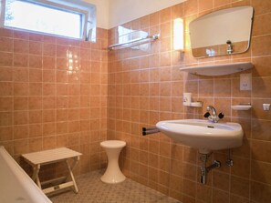 A bathroom with a white sink, a mirror, and a toilet.