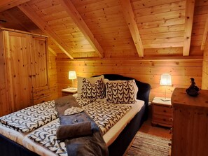 A cozy wooden cabin bedroom with a bed, two bedside tables, and a wardrobe. - Chalet Bergliebe Turrach (Stadl-Predlitz)
