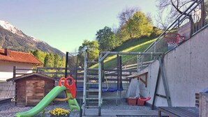 Un’area giochi con uno scivolo, altalene e una struttura per arrampicarsi.