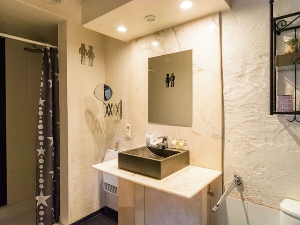 A bathroom with a vanity, a mirror, a shower, and a towel rack.