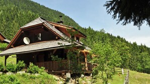 A wooden cabin with a sloped roof, a balcony, and a stone foundation. - Chalet in Kolbnitz Near Ski Slopes (Reisseck)