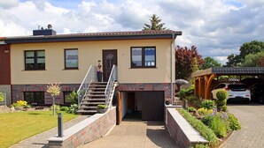 A two-story house with a front entrance, a staircase, and a covered outdoor area. - Damshagen Kustenkomfort (Damshagen)