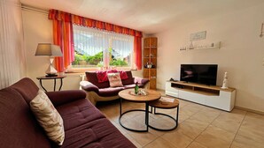 A living room with a sofa, a coffee table, a TV, and a lamp. - Damshagen Kustenkomfort (Damshagen)