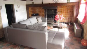 A living room with a sofa, a fireplace, and a patterned floor.