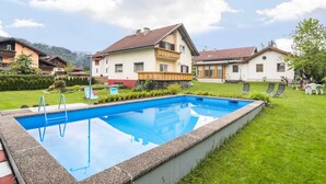 A residential area with a swimming pool, houses with balconies, and a clear sky. - Holiday Apartment in Tropolach (Hermagor-Pressegger See)