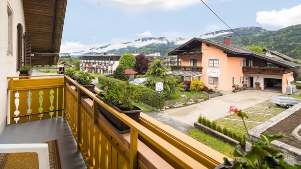 A balcony with yellow railings overlooking a town with traditional buildings and a mountain backdrop. - Holiday Apartment in Tropolach (Hermagor-Pressegger See)