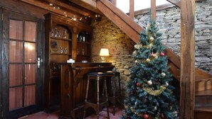 A rustic interior with a wooden bar, stone walls, and a decorated Christmas tree. - Holiday Home in Ronchampay (La Roche-en-Ardenne)