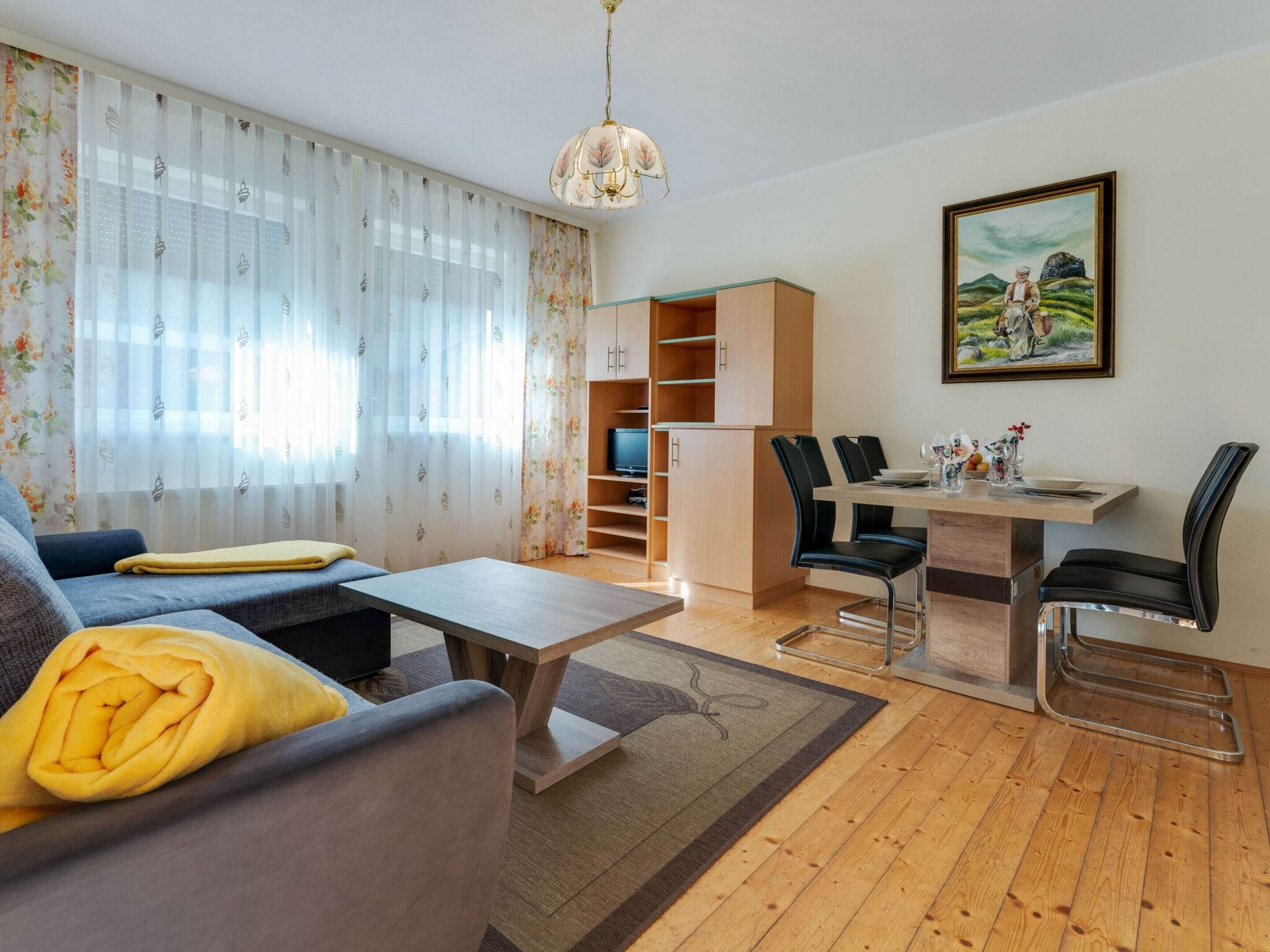 Un salon comprenant un canapé, une table basse et un coin repas avec des chaises et une table.