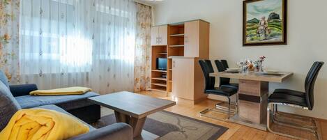 Un salon comprenant un canapé, une table basse et un coin repas avec des chaises et une table.