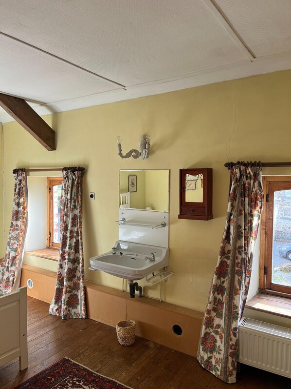 A bathroom with a sink, mirror, and window with curtains. - Charming Castle in Roumont (Bertogne)