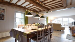 A dining area with a wooden table, chairs, and pendant lights.