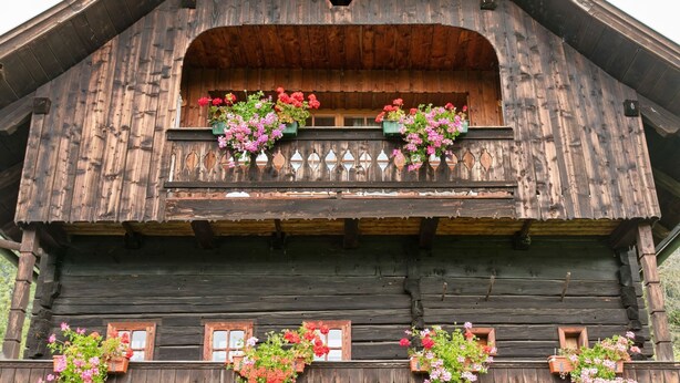 Um edifício de madeira tradicional com várias varandas, cada uma delas decorada com caixas de flores.