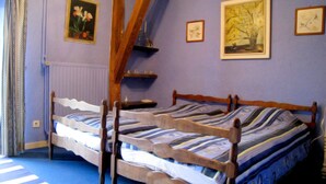 A bedroom with two wooden beds, a sloped ceiling, and a window with curtains. - Cozy Cottage in Barvaux-Condroz near Forest (Havelange)