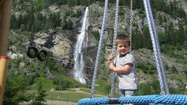 A child on a swing with a waterfall in the background. - Historic Holiday Home in Gmünd near Cross Country Skiiing (Gmuend in Kaernten)