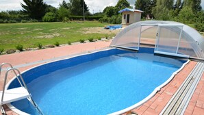 A rectangular swimming pool with a diving board and a covered area. - Country House in Czech Forest With Pool (Horní Kozolupy)