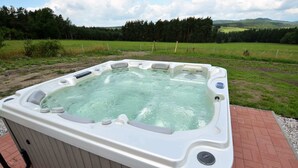 A hot tub outdoors with a scenic view of a forest and hills in the background. - Country House in Czech Forest With Pool (Horní Kozolupy)