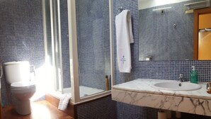 Un baño con inodoro, lavamanos y espejo.